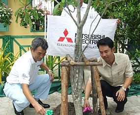 Hidetoshi Kan (left), managing director of Mitsubishi Elevator Thailand Co., Ltd., and Mayor Itthiphol Kunplome plant a tree to mark the 88th anniversary of Pattaya School #8.